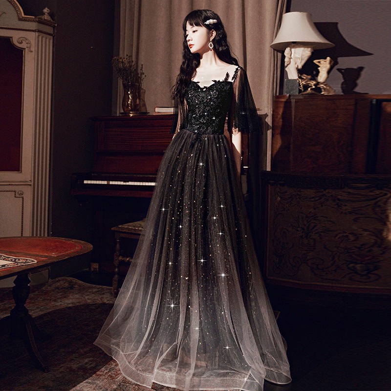 Elegant black annual French dinner dress with glittering tulle skirt and lace bodice in vintage room setting