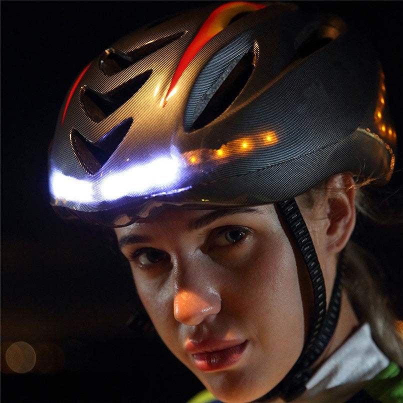 Woman wearing intelligent steering helmet with integrated LED turn signals and front white light at night