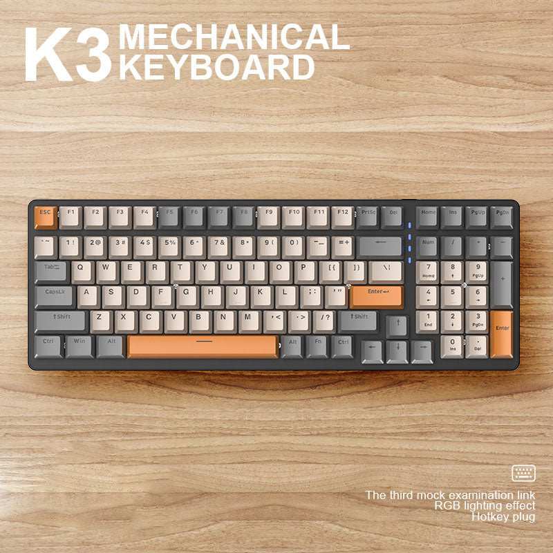 Black and orange K3 mechanical keyboard with 100 keys and RGB lighting on wooden surface