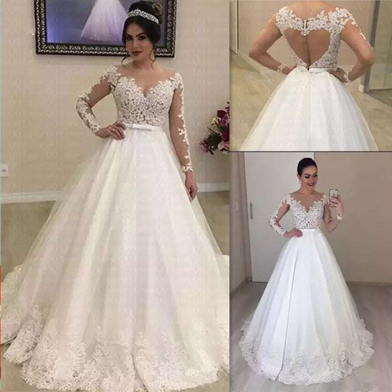 Bride wearing white applique long sleeve wedding dress with lace details and full skirt