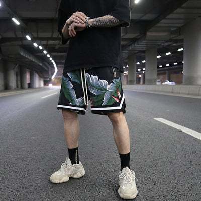 Men's floral loose shorts with tropical leaf pattern, low waist, elastic fit, straight cut above the knees, casual beachwear.