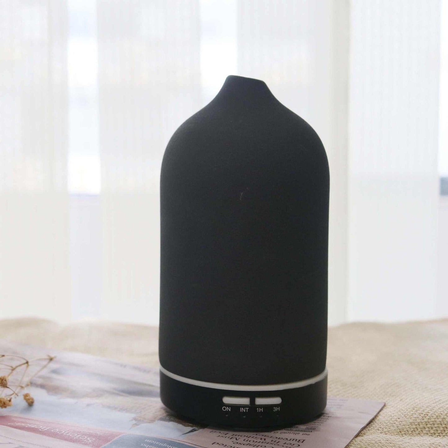 Black ceramic ultrasonic air humidifier and aroma diffuser with 100ml capacity for essential oils.