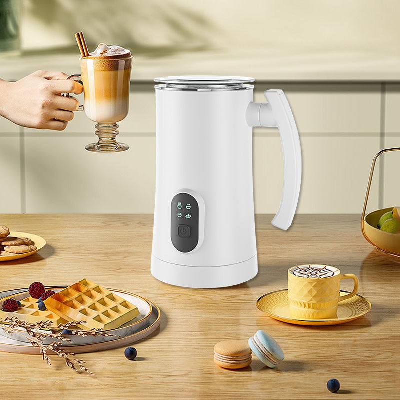 Home automatic stainless steel electric milk frother with button control for hot and cold milk, shown on kitchen table with coffee and snacks.