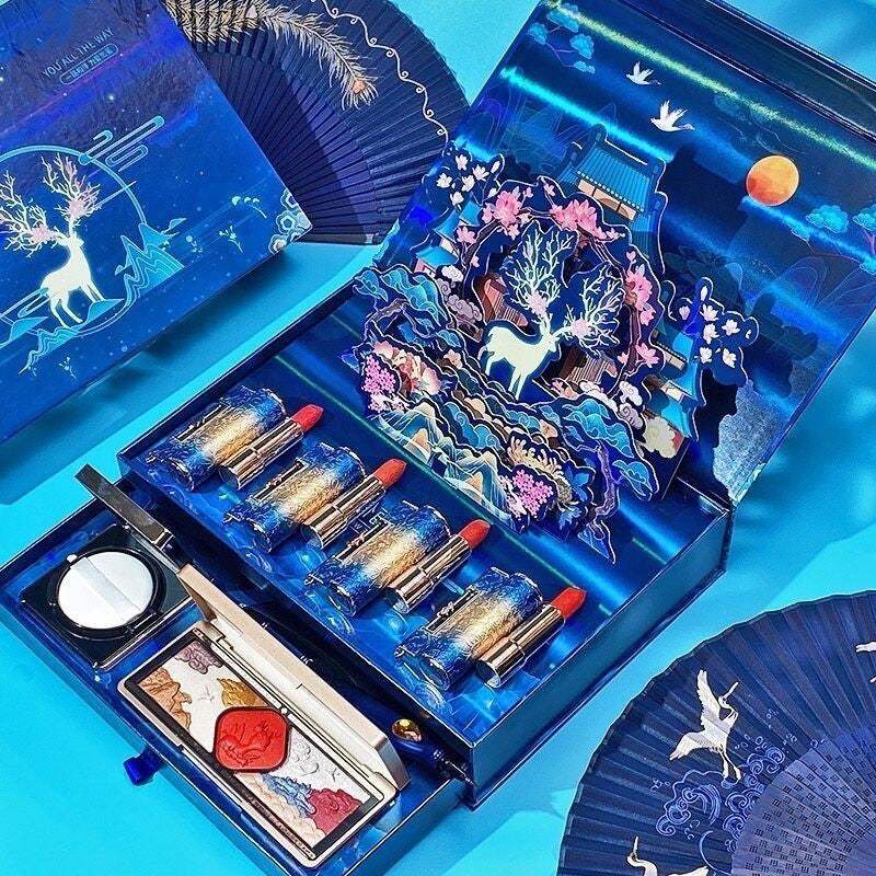 Luxury lipstick and eye shadow suit in a decorative blue box with artistic deer and floral design