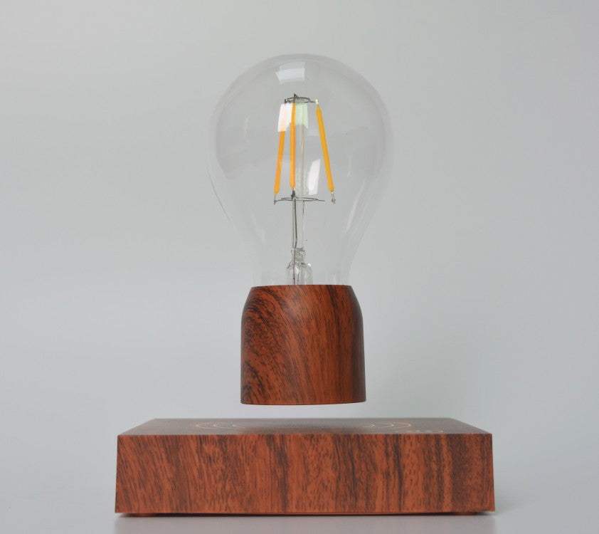 Factory household magnetic levitation bulb floating above wooden base with clear glass and filament design