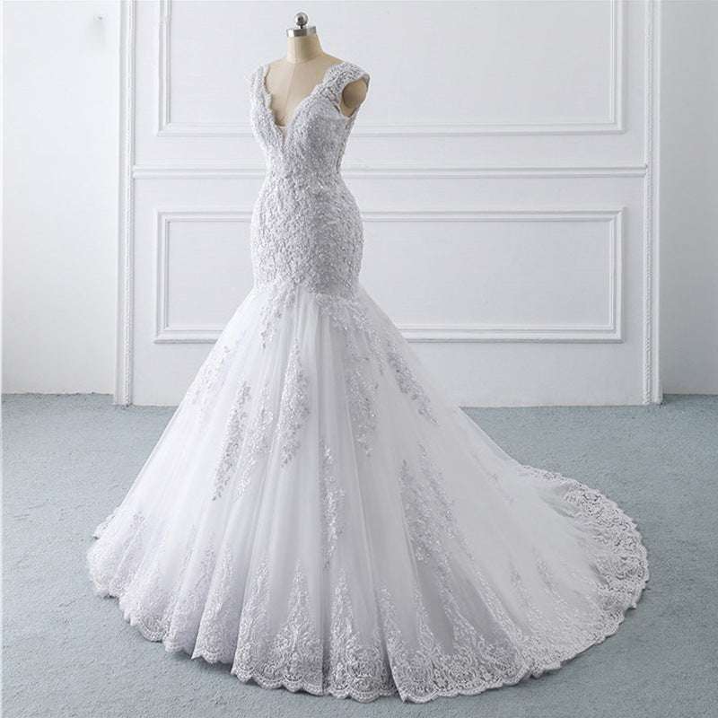White mermaid light wedding dress with lace details and fishtail train on mannequin