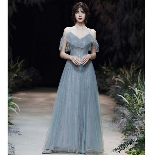 woman wearing dark gray lace evening dress with off-shoulder sleeves standing on runway