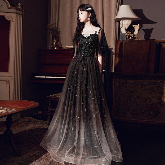 Elegant black annual French dinner dress with glittering tulle skirt and lace bodice in vintage room setting
