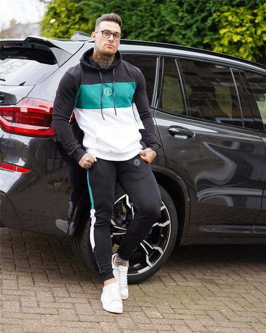 Man wearing fitness suit splicing contrast color hooded suit standing by black SUV outdoors