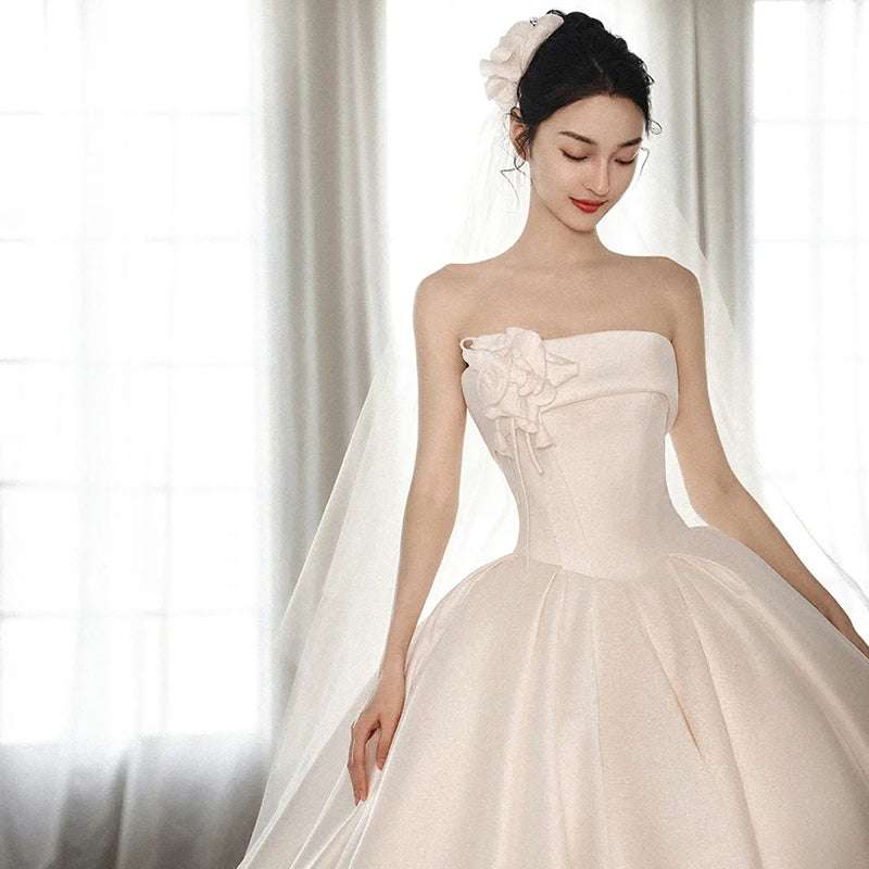 Elegant strapless satin dress with a big train and floral detail at the bodice