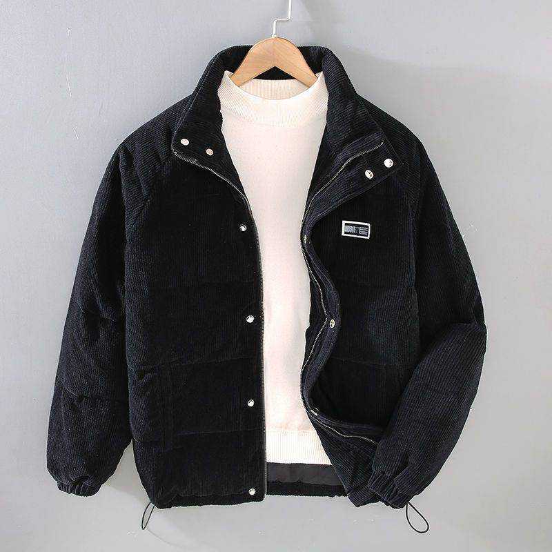 Black puffer jacket coat with snap buttons and elastic cuffs hanging on wooden hanger, styled with white turtleneck sweater.