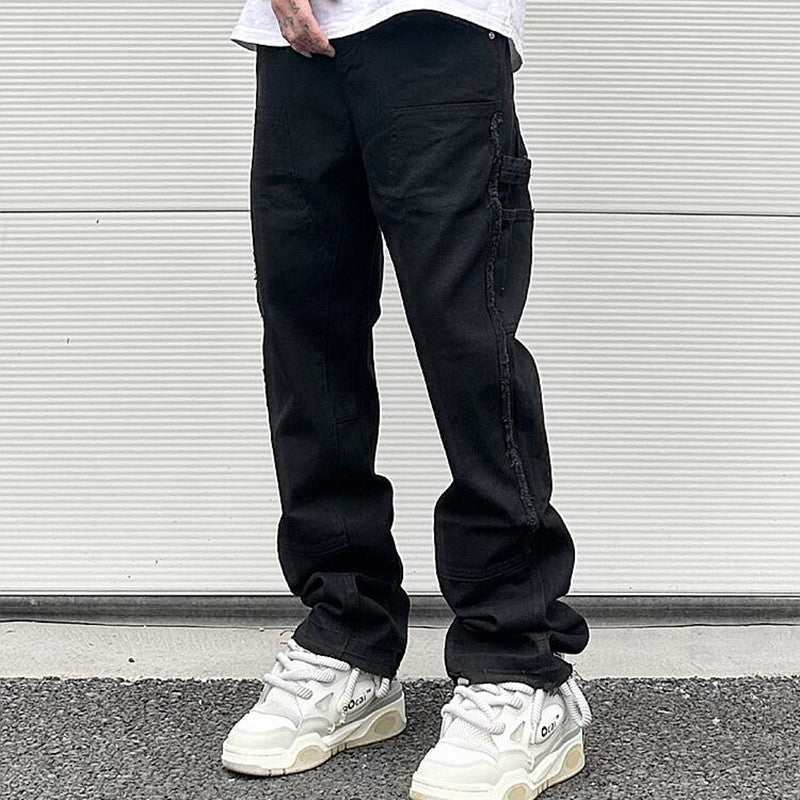 Men's black high street straight leg jeans with zipper and mid-waist design worn with white sneakers