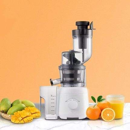 White multi-function juicer with separator and control knob, surrounded by fresh mangoes, oranges, and a glass of juice on a marble surface against an orange background.