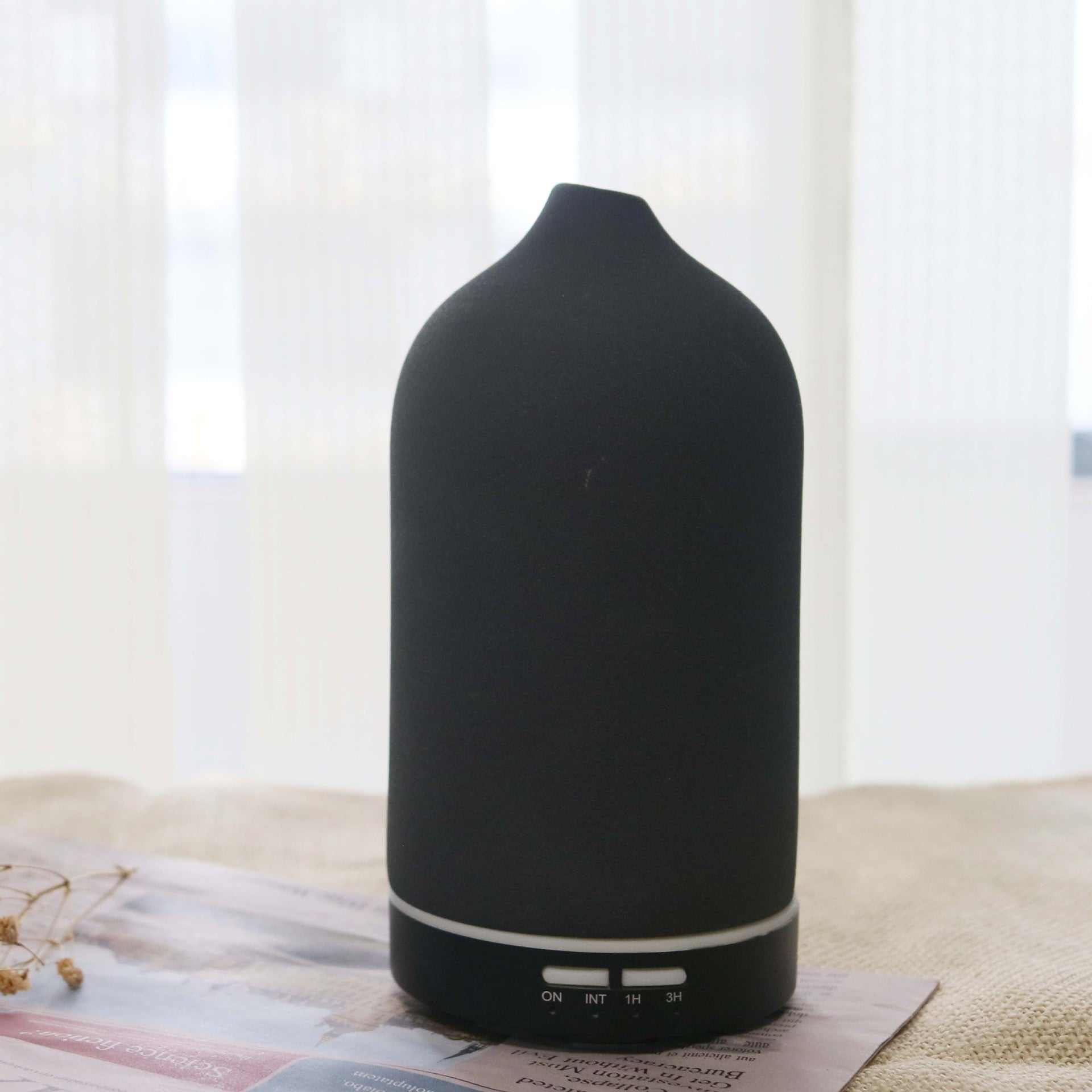 Black ceramic ultrasonic air humidifier and aroma diffuser with 100ml capacity for essential oils.