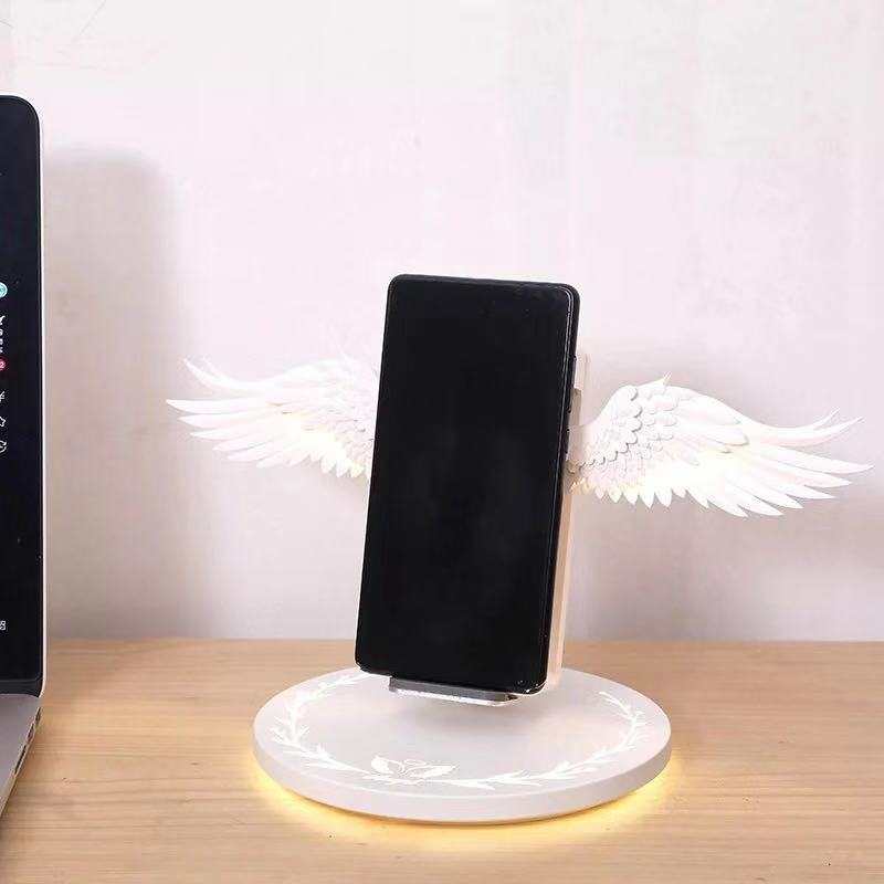 Angel Wings Wireless Charger with unfolded wings design and phone charging on round base with glowing angel aura