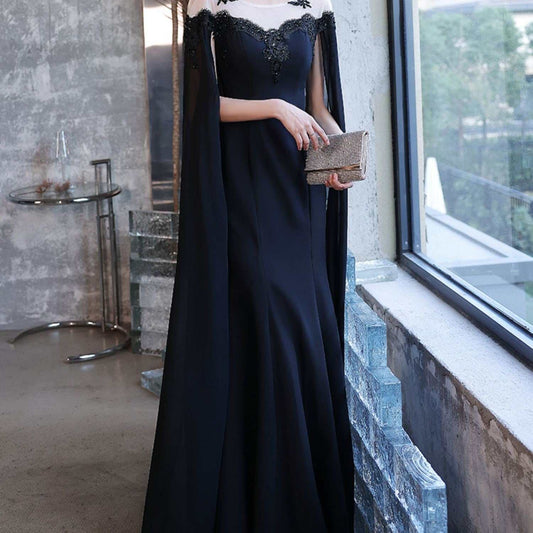 Elegant black evening dress for women with U-neck, sequins, and zipper detail, styled with a cape and mid-waist fit.
