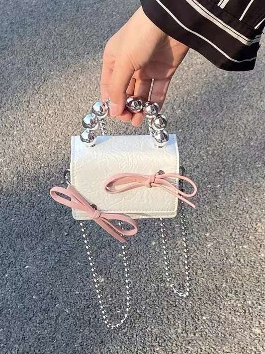 Textured Cute Bow Mini Chain Handbag - AMIR BAGS INDIA PRIVATE LIMITED
